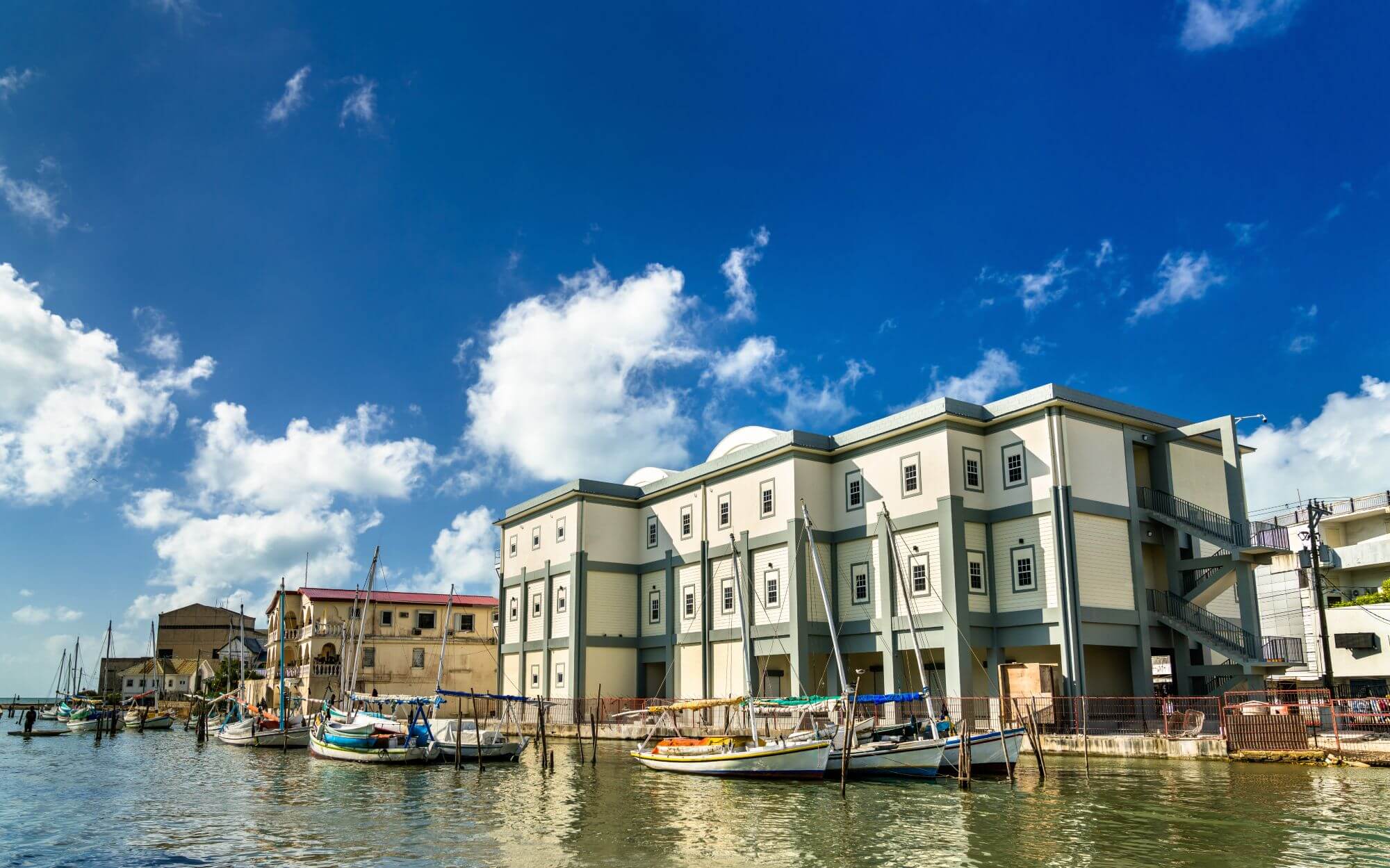Beautiful buildings coming right up to the water and the boats being mored along the embankment in Belize City