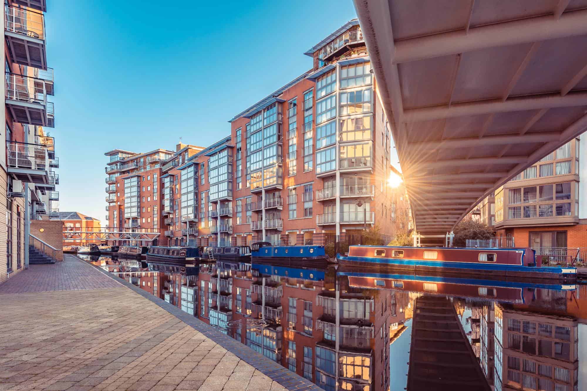 Birmingham canal in the evening with bright lights and buildings refleted in the water