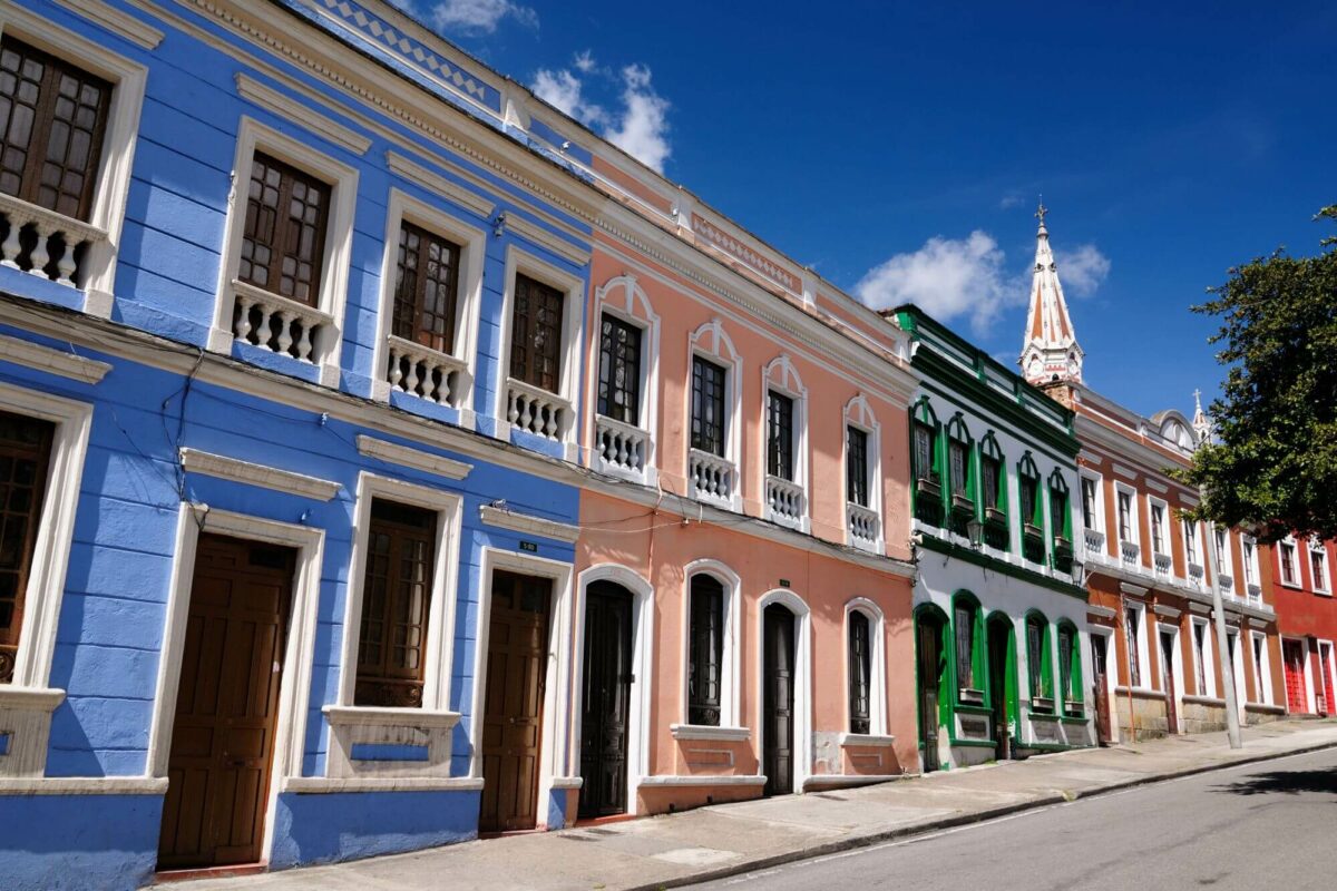 A hilly street framed by traditional terraced houses in various colors