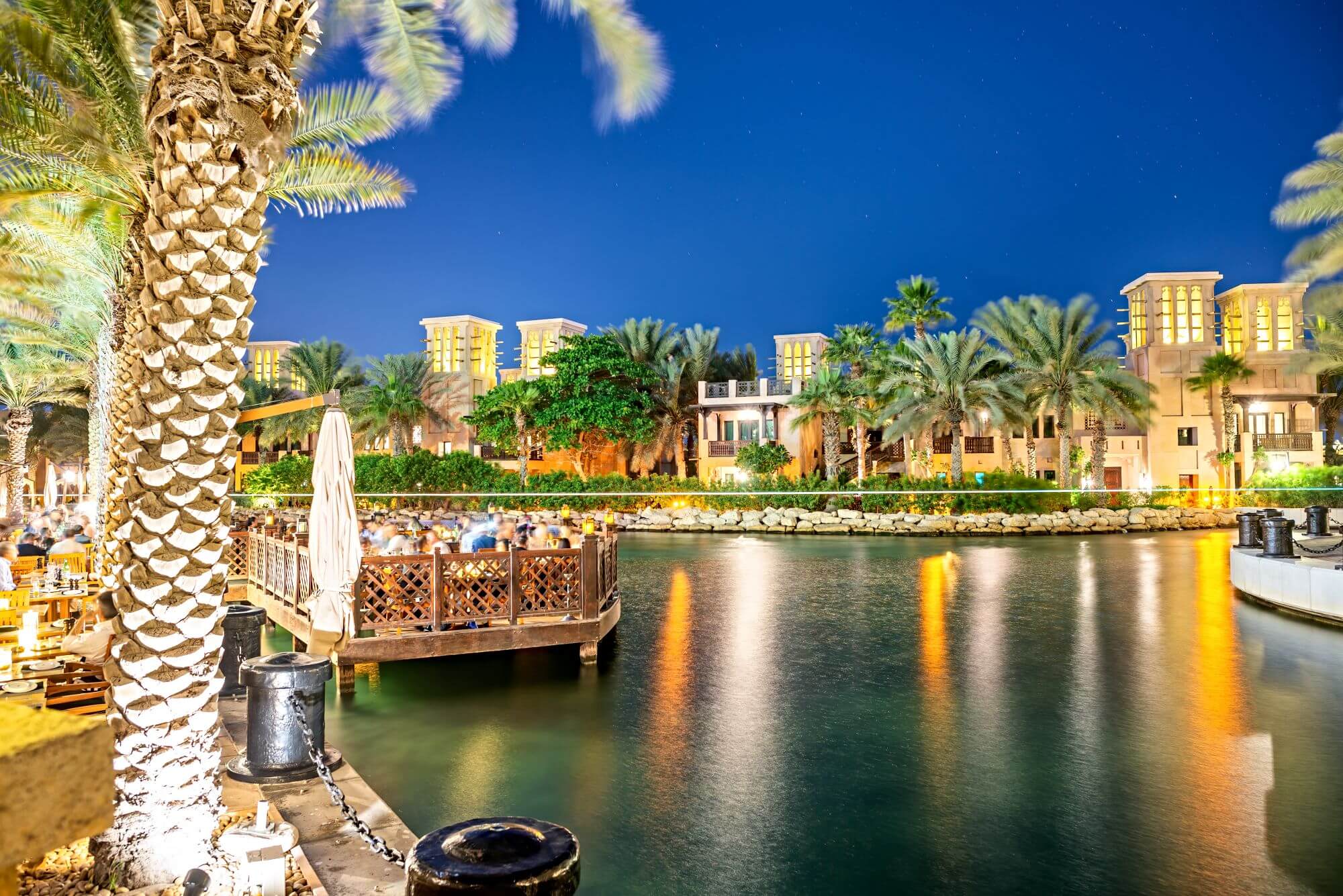 people in an open cafe in Dubai Jumeirah in the evening enjoying food and drinks