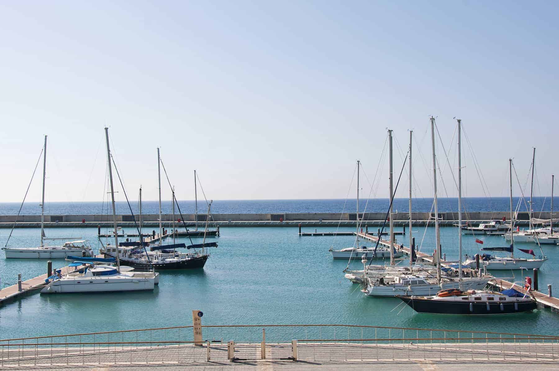 A modern marina with luxury yachts on a sunny day