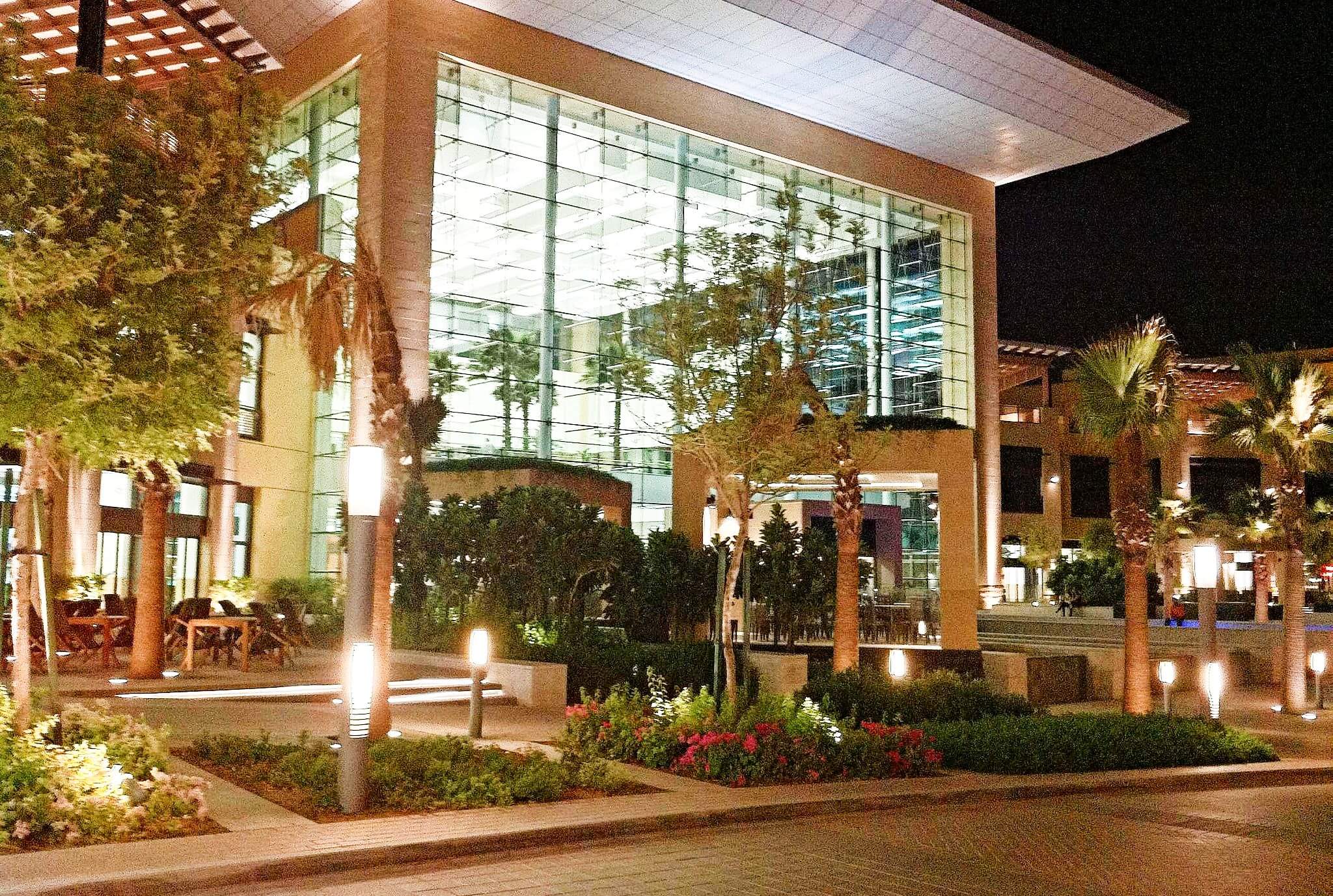 A vibrant city street at night - lit up buildings and public spaces in Mirdif in Dubai