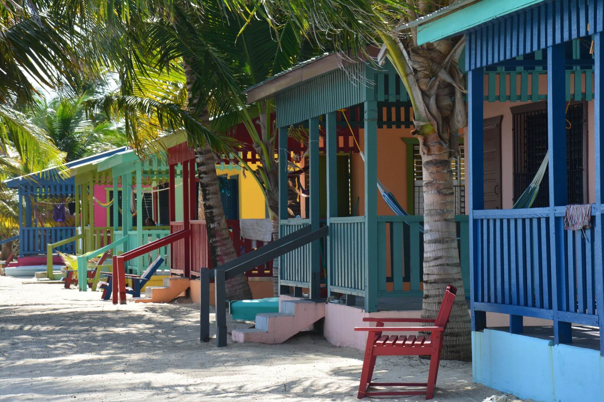 Colorful bungalows on a sandy tropical beach in Belize