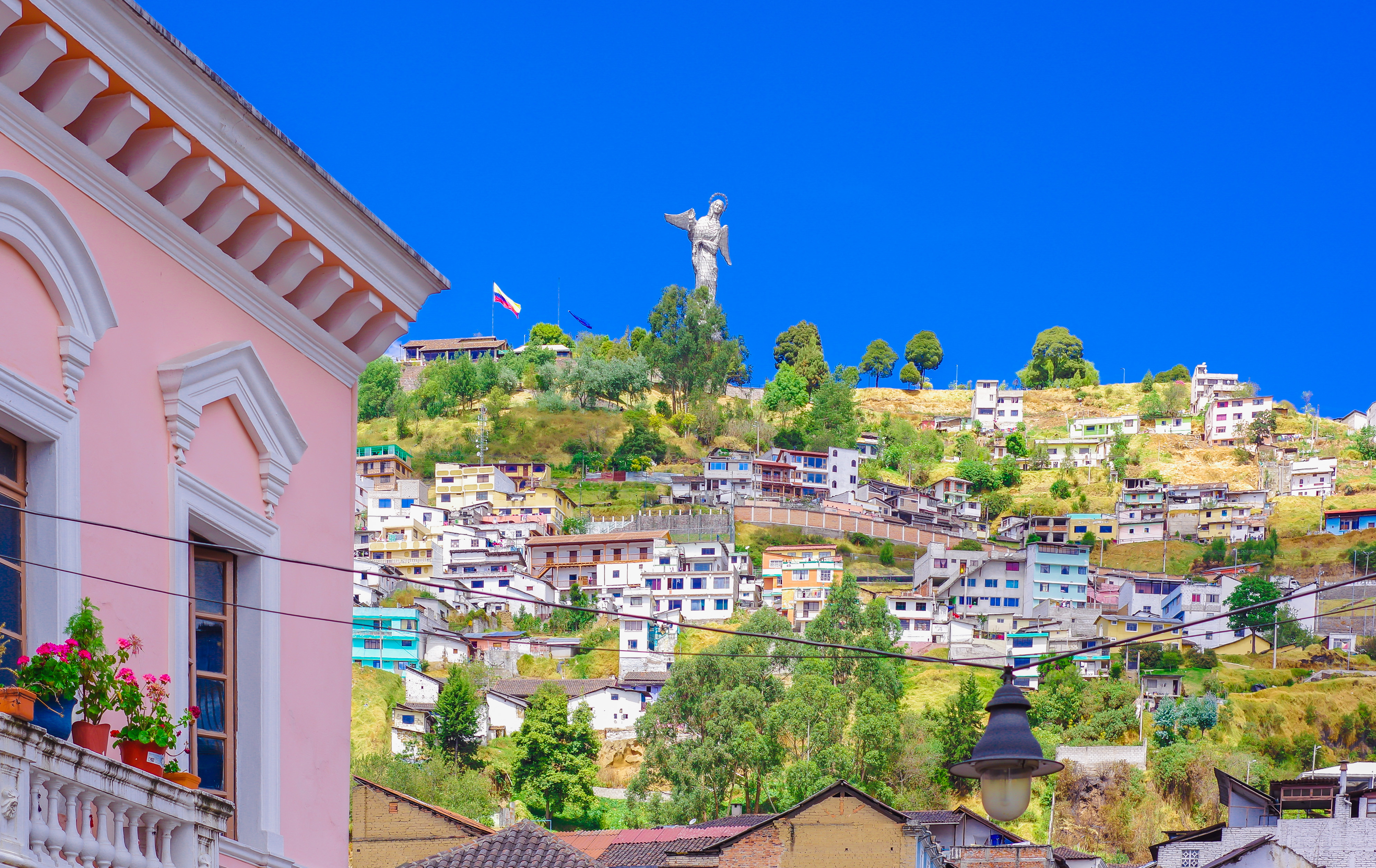 An impressive panoramic view of Quito, Ecuador, nestled in a valley surrounded by the Andes mountains.