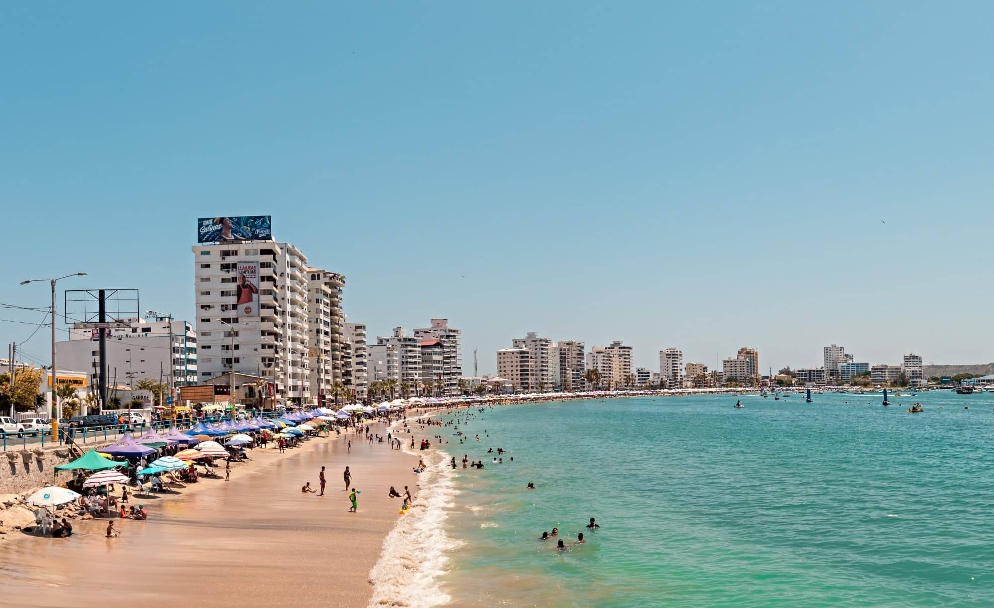 A city beach of Salinas, Ecuador - a sandy stretch along the sea with apartment blocks in the background