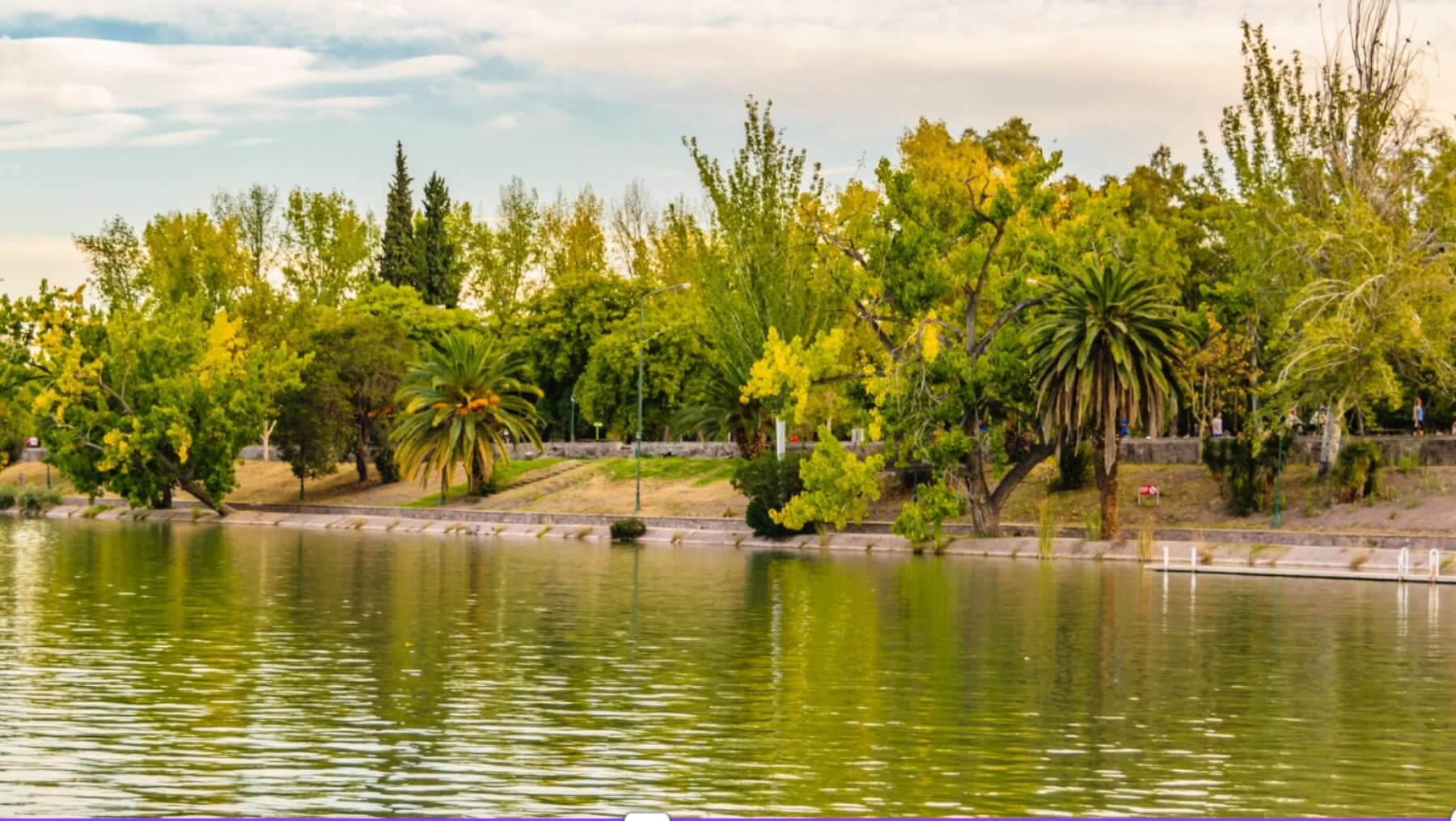 A city park by the river - manicured gardens and greenery along the river edge